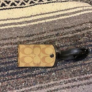 Coach luggage tag in signature canvas.  Tan and brown in color.
